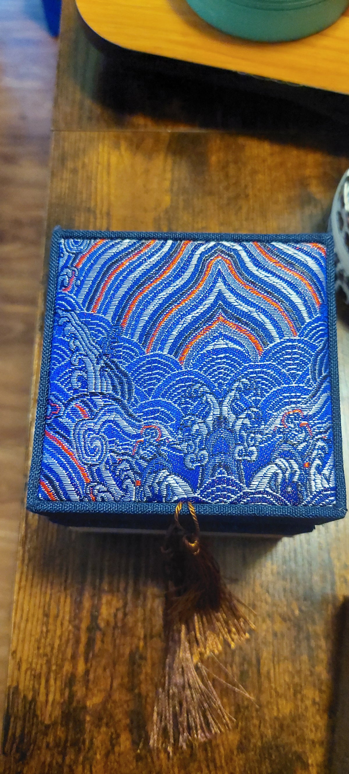 Assorted small decorative jewelry boxes in various colors and patterns, displayed on a table.