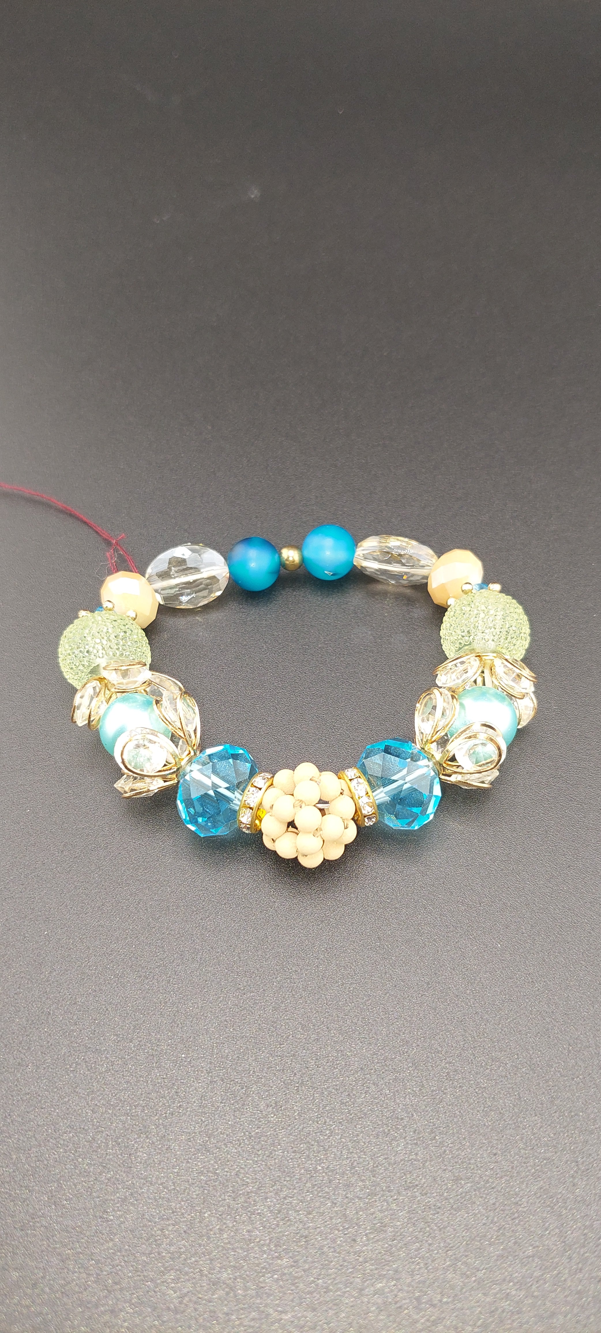 A light blue chunky bracelet with a mix of solid and patterned beads displayed against a neutral background.