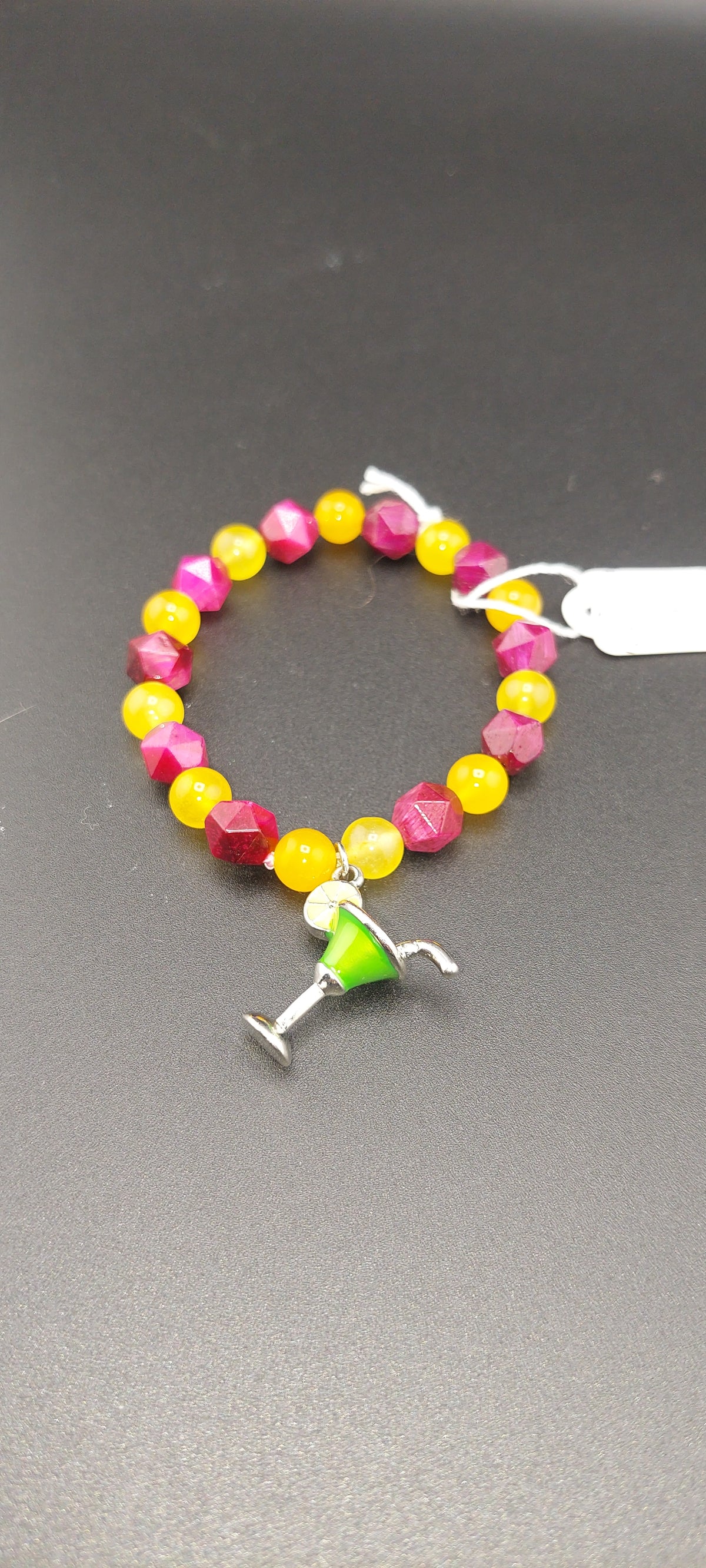 A bracelet with multicolored beads and a margarita glass charm.