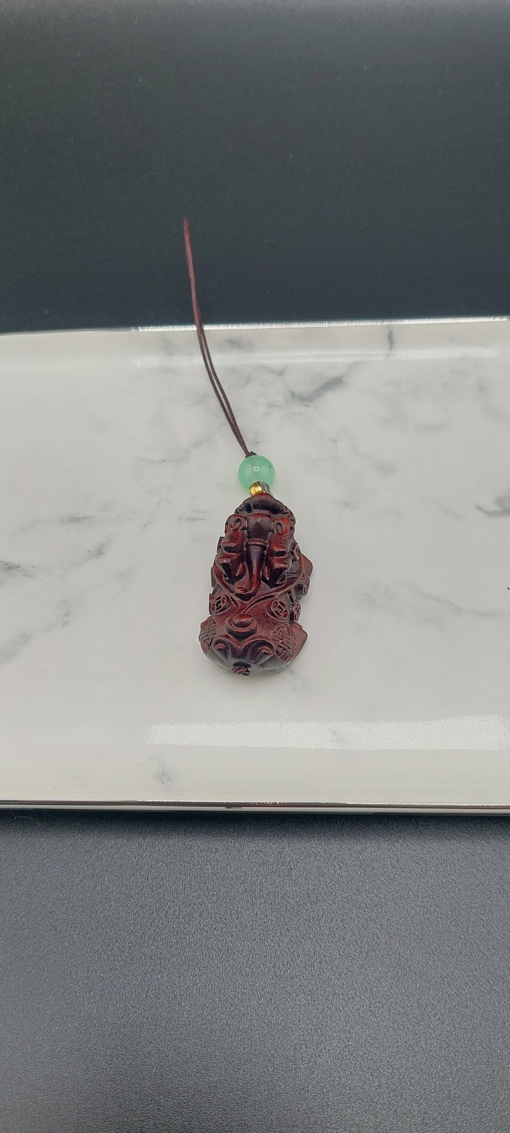A brown wooden keychain with a carved design displayed on a white surface.
