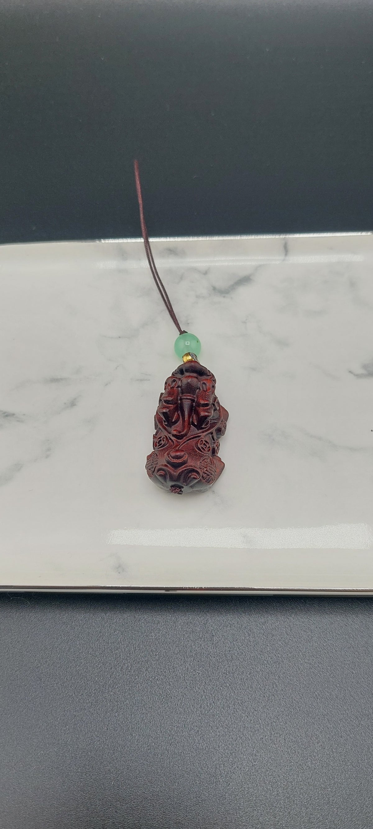 A brown wooden keychain with a carved design displayed on a white surface.