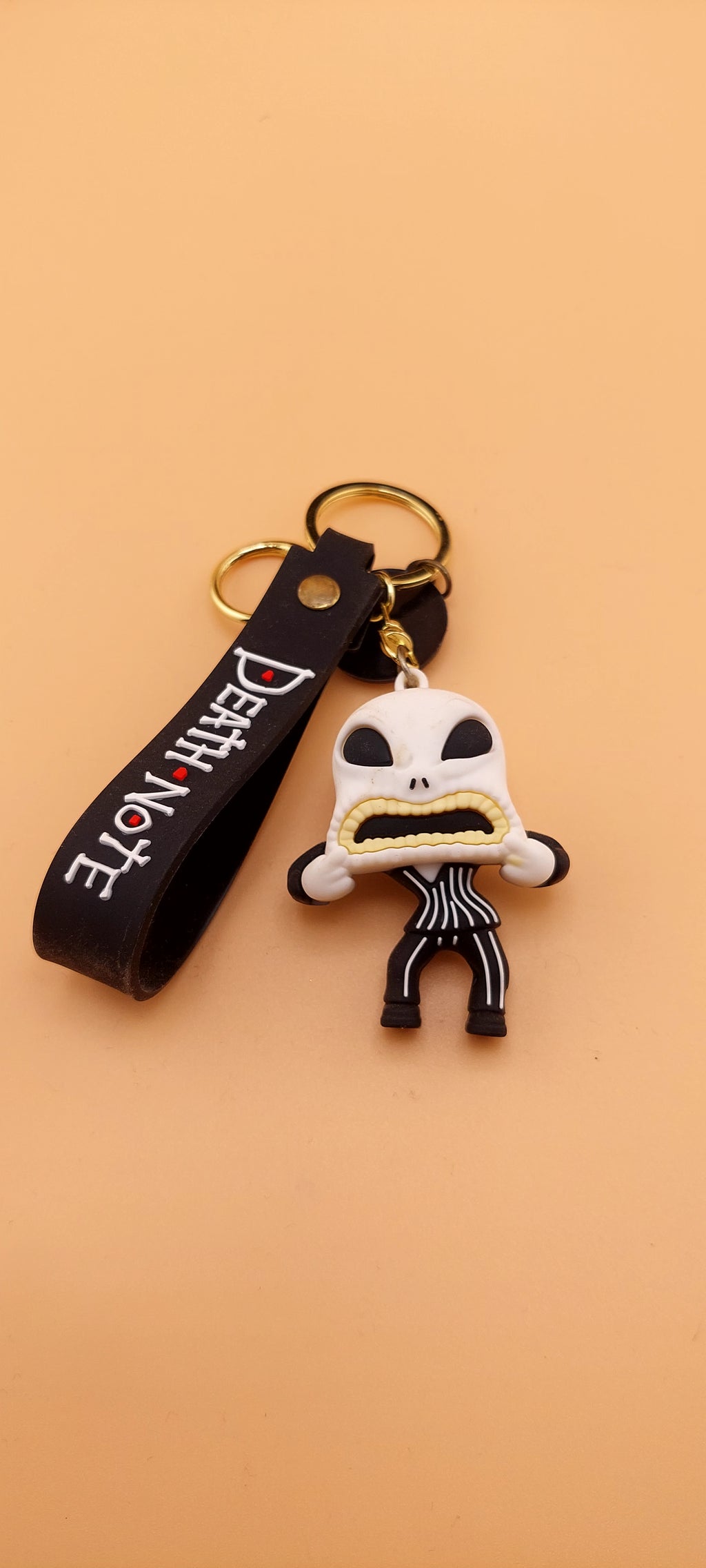 A keychain featuring an animated character from 'The Nightmare Before Christmas' attached to a brown strap with the text 'DEATH NOTE'.
