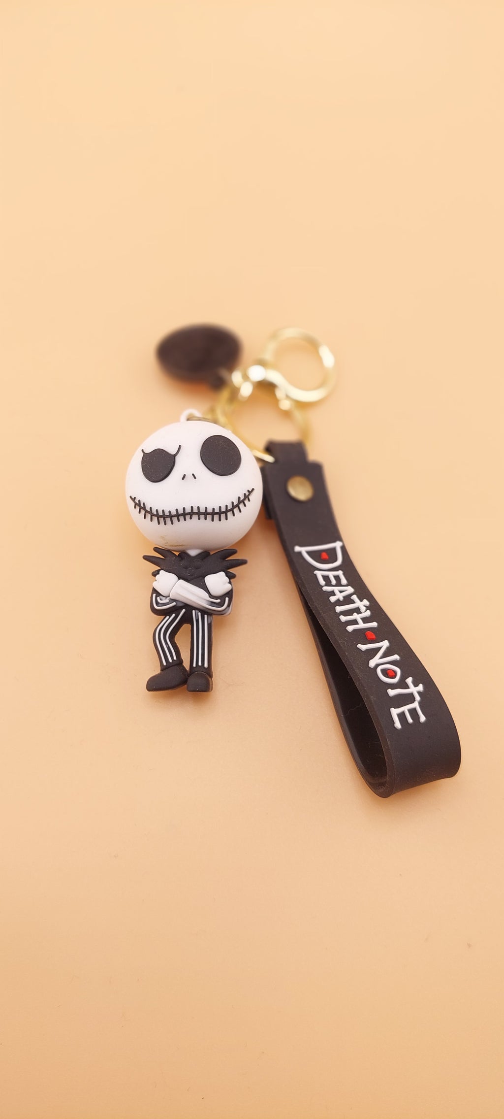 A keychain featuring an animated character from 'The Nightmare Before Christmas' attached to a brown strap with the text 'DEATH NOTE'.