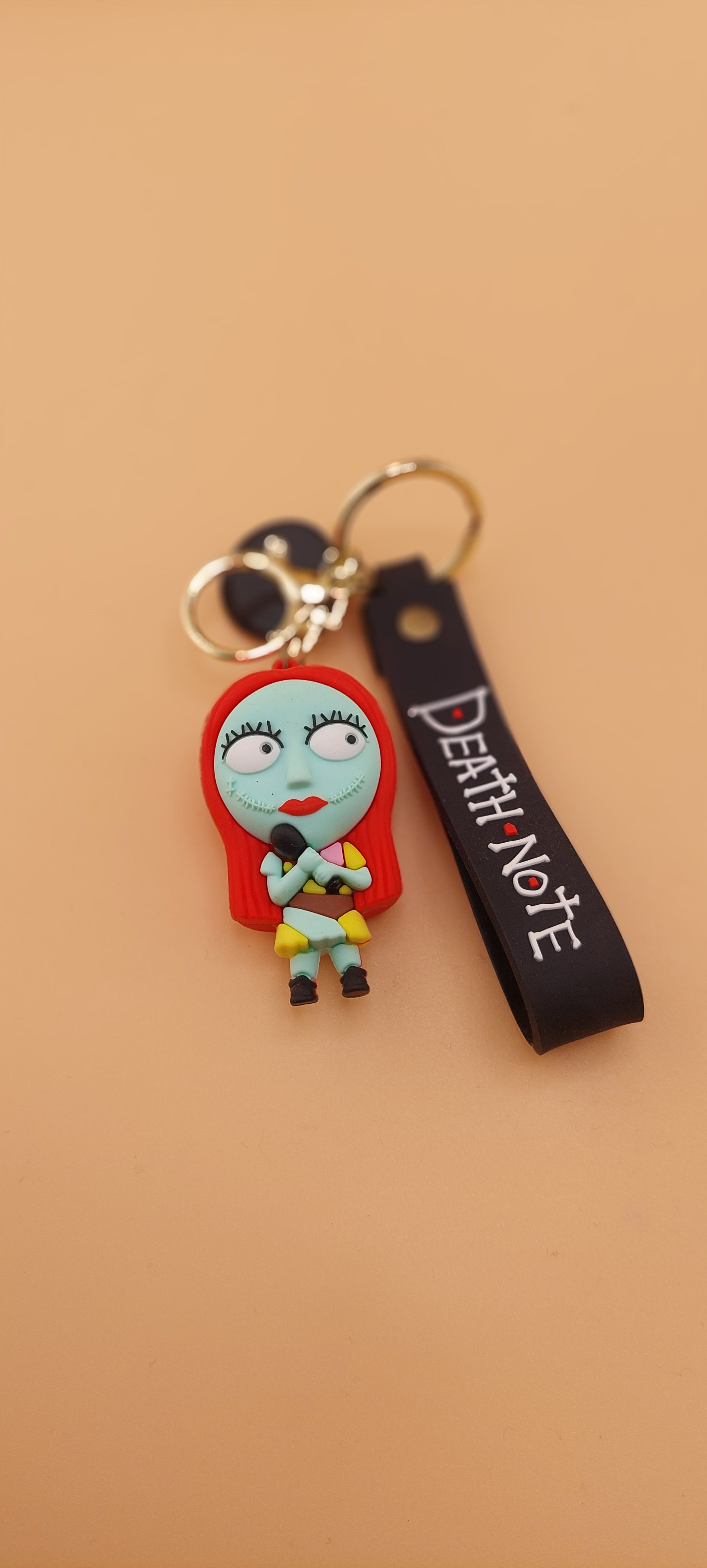 A keychain featuring an animated character from 'The Nightmare Before Christmas' attached to a brown strap with the text 'DEATH NOTE'.