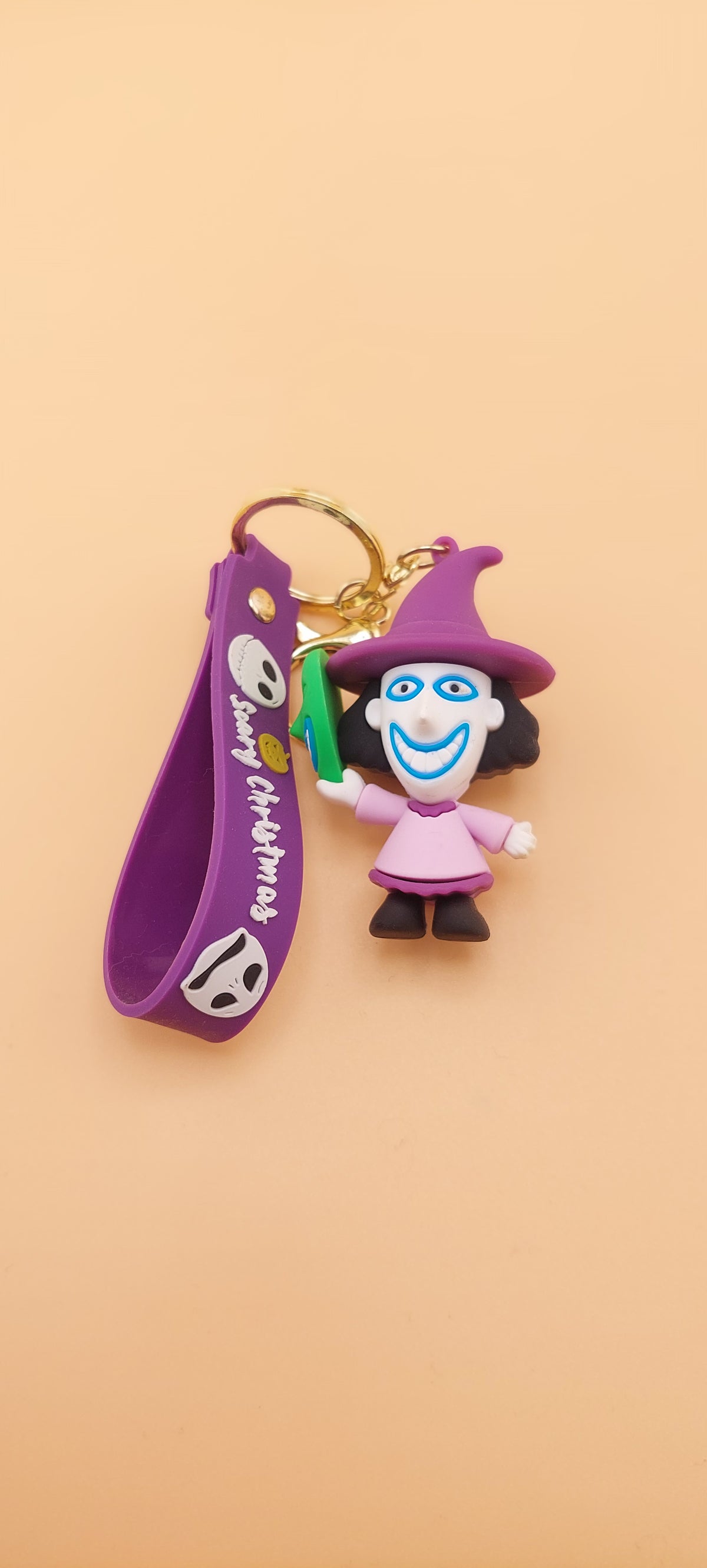 A keychain featuring an animated character from 'The Nightmare Before Christmas' attached to a purple strap 