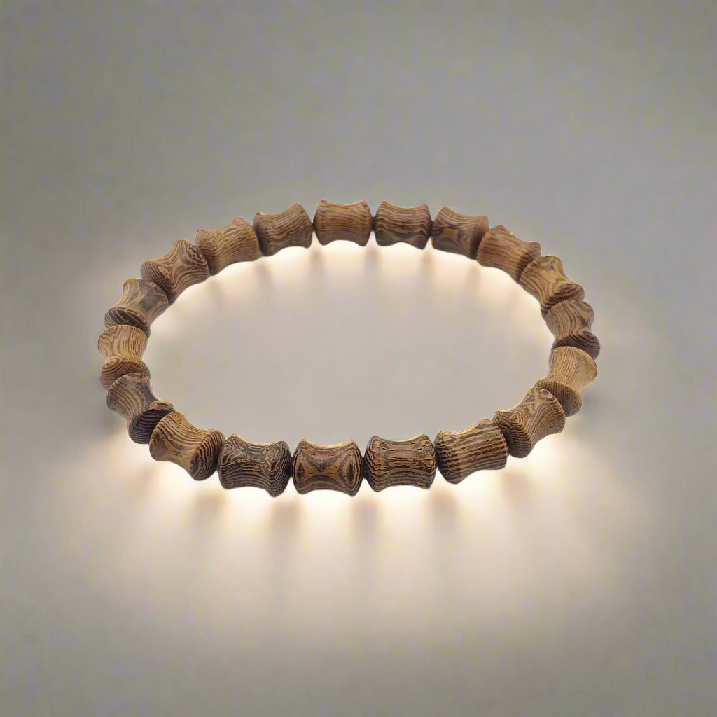 A bracelet made of sandle wood with bamboo-shaped beads, displayed against a neutral background.