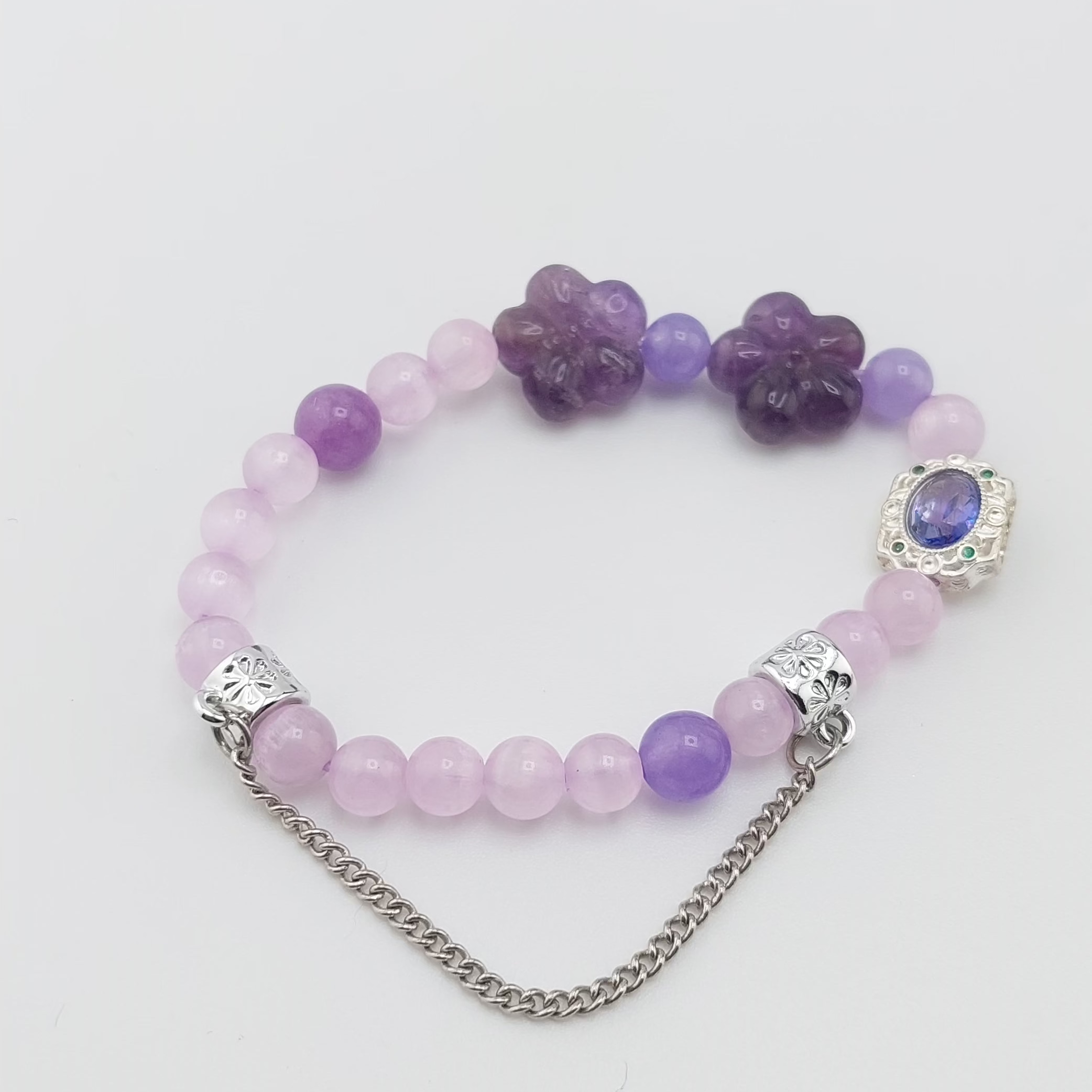 Purple flower bracelet with silver charms and fine silver chain.