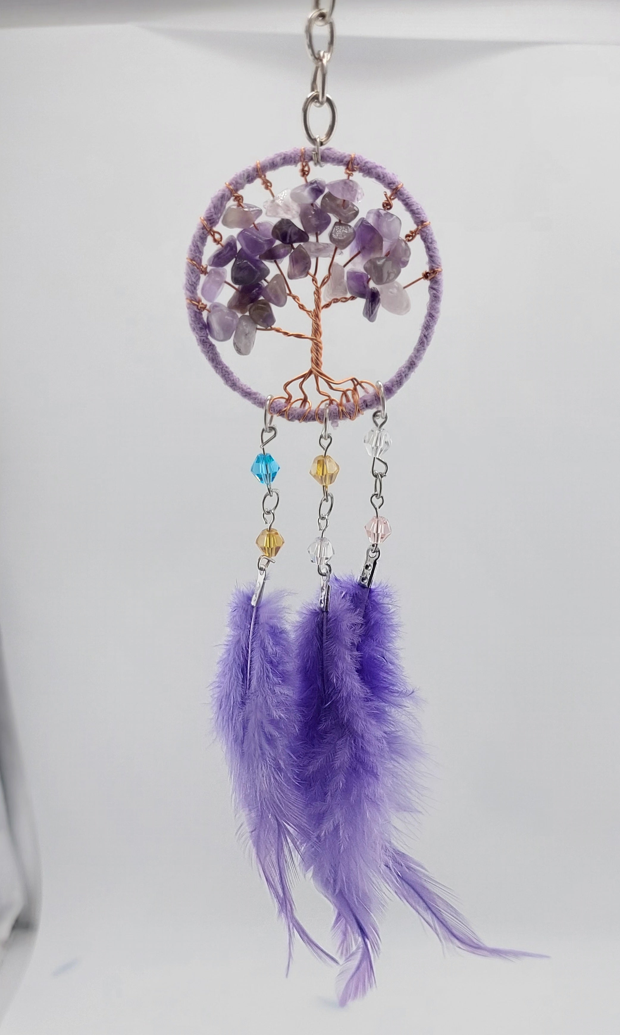 A set of three dream catcher keychains with stone crystal chips and decorative tree of life designs, featuring blue, white, and purple feathers.