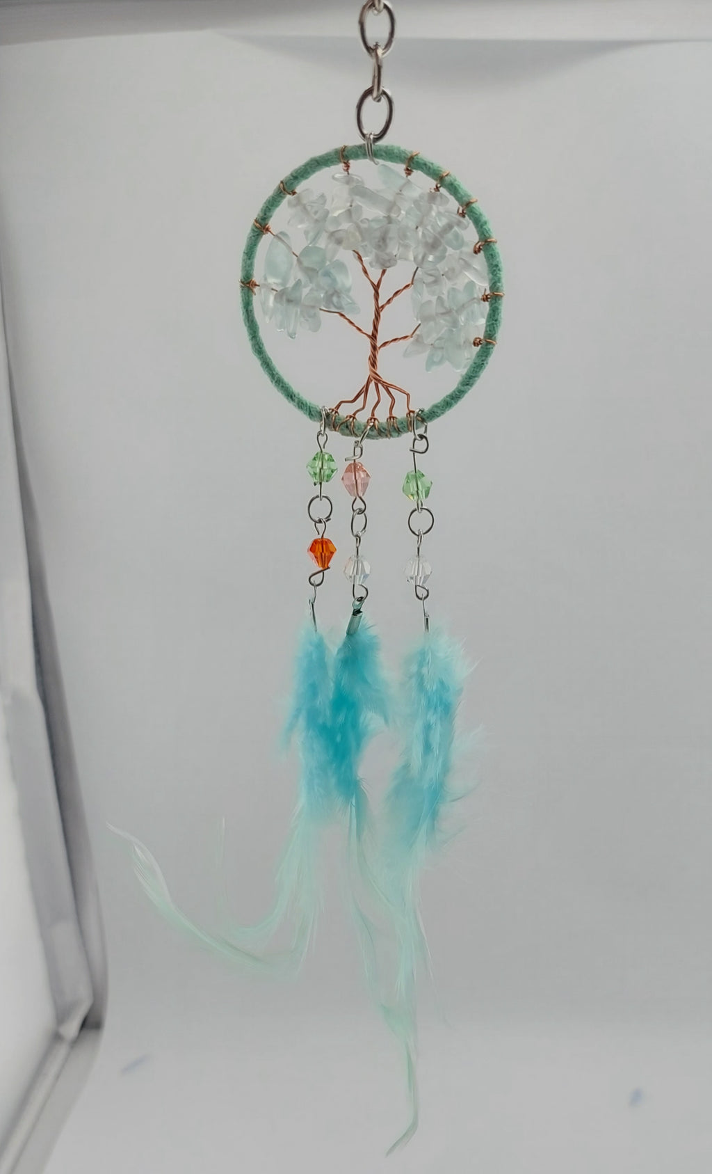 A set of three dream catcher keychains with stone crystal chips and decorative tree of life designs, featuring blue, white, and purple feathers.