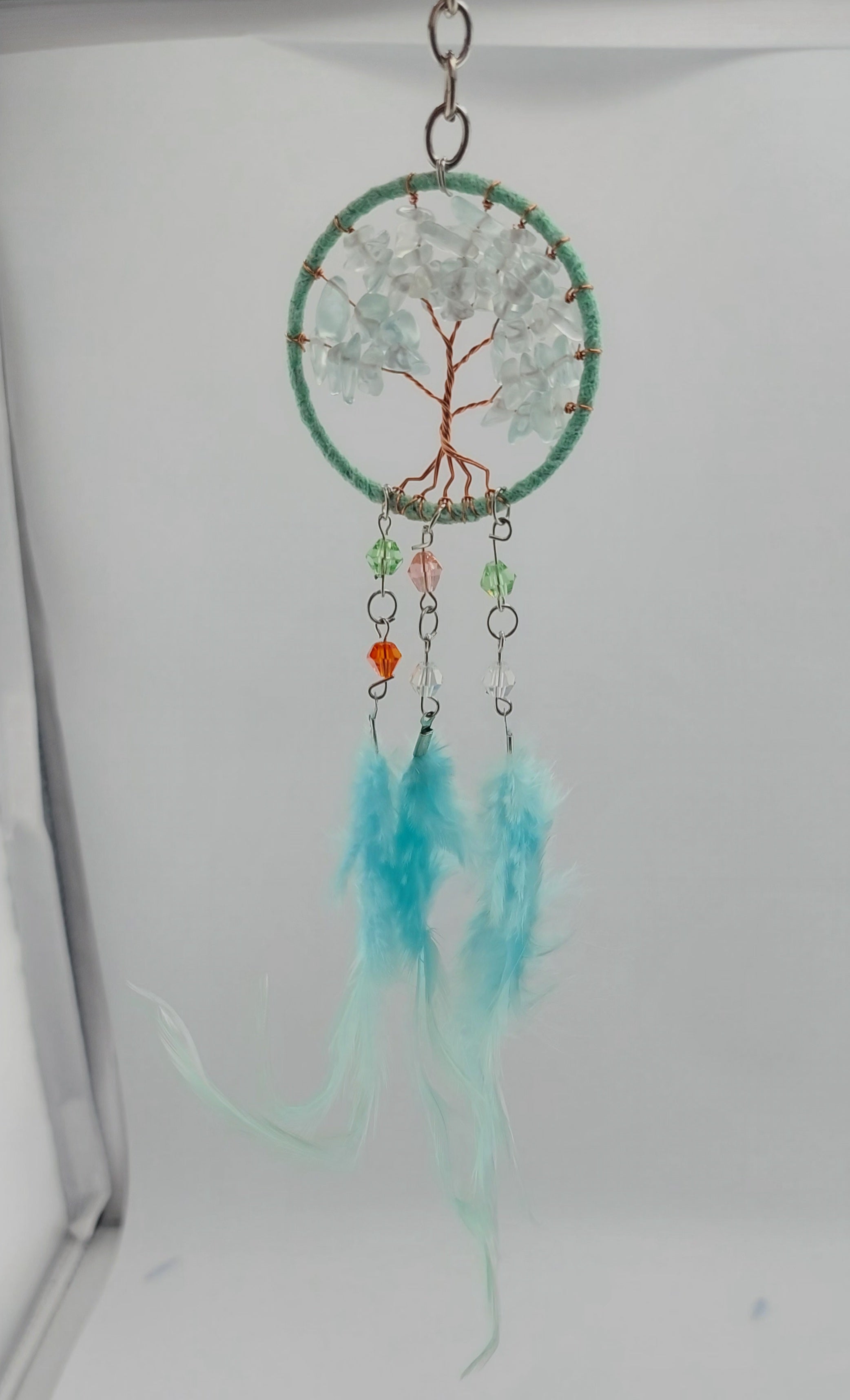 A set of three dream catcher keychains with stone crystal chips and decorative tree of life designs, featuring blue, white, and purple feathers.