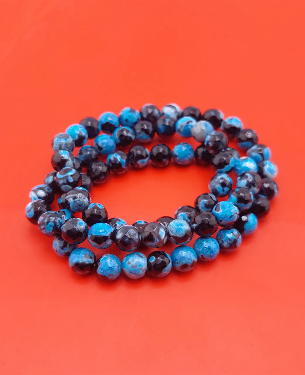 A bracelet with purple beads displayed on a red background.
