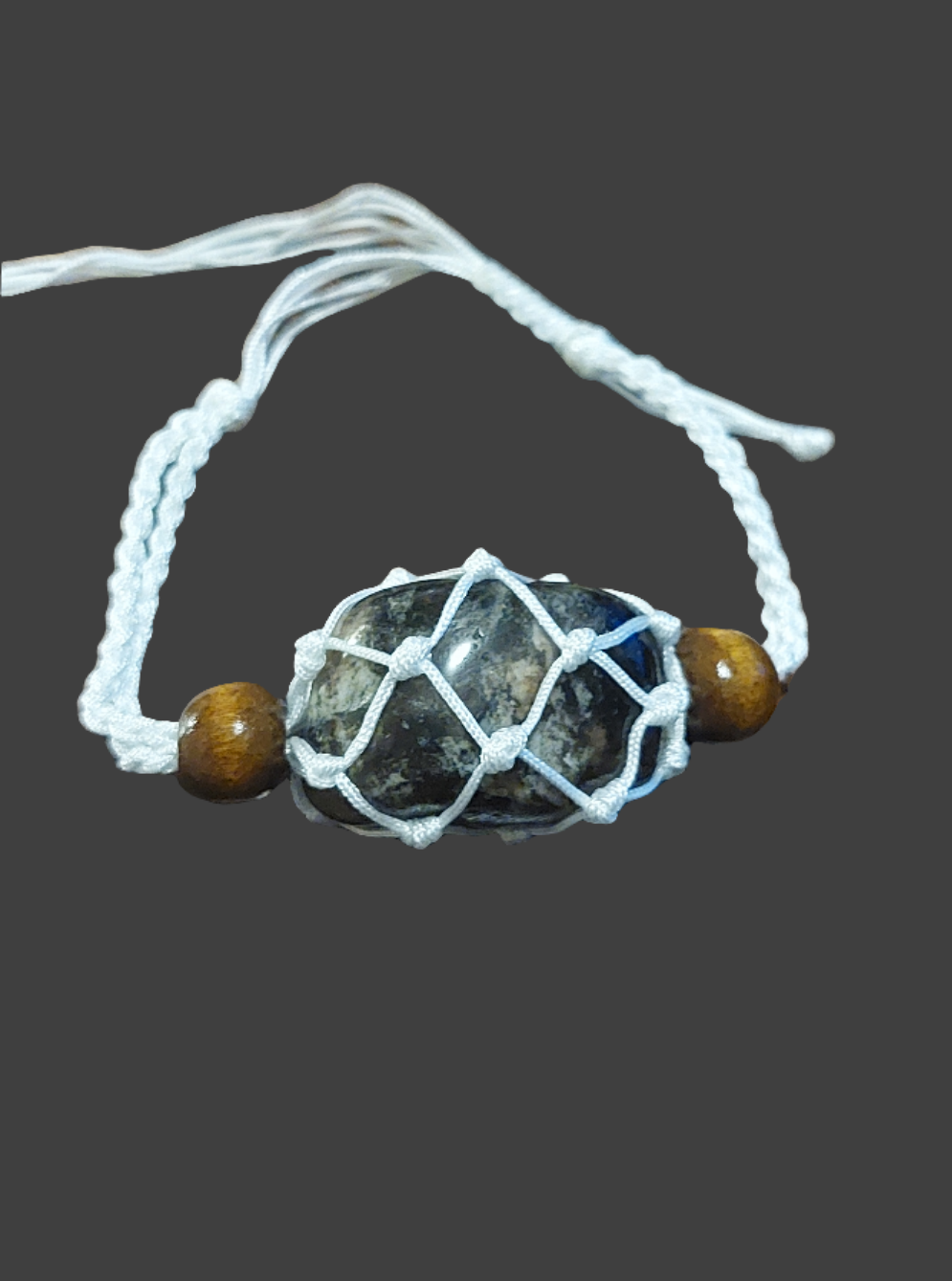 white macrame tumbled stone bracelet behind grey background