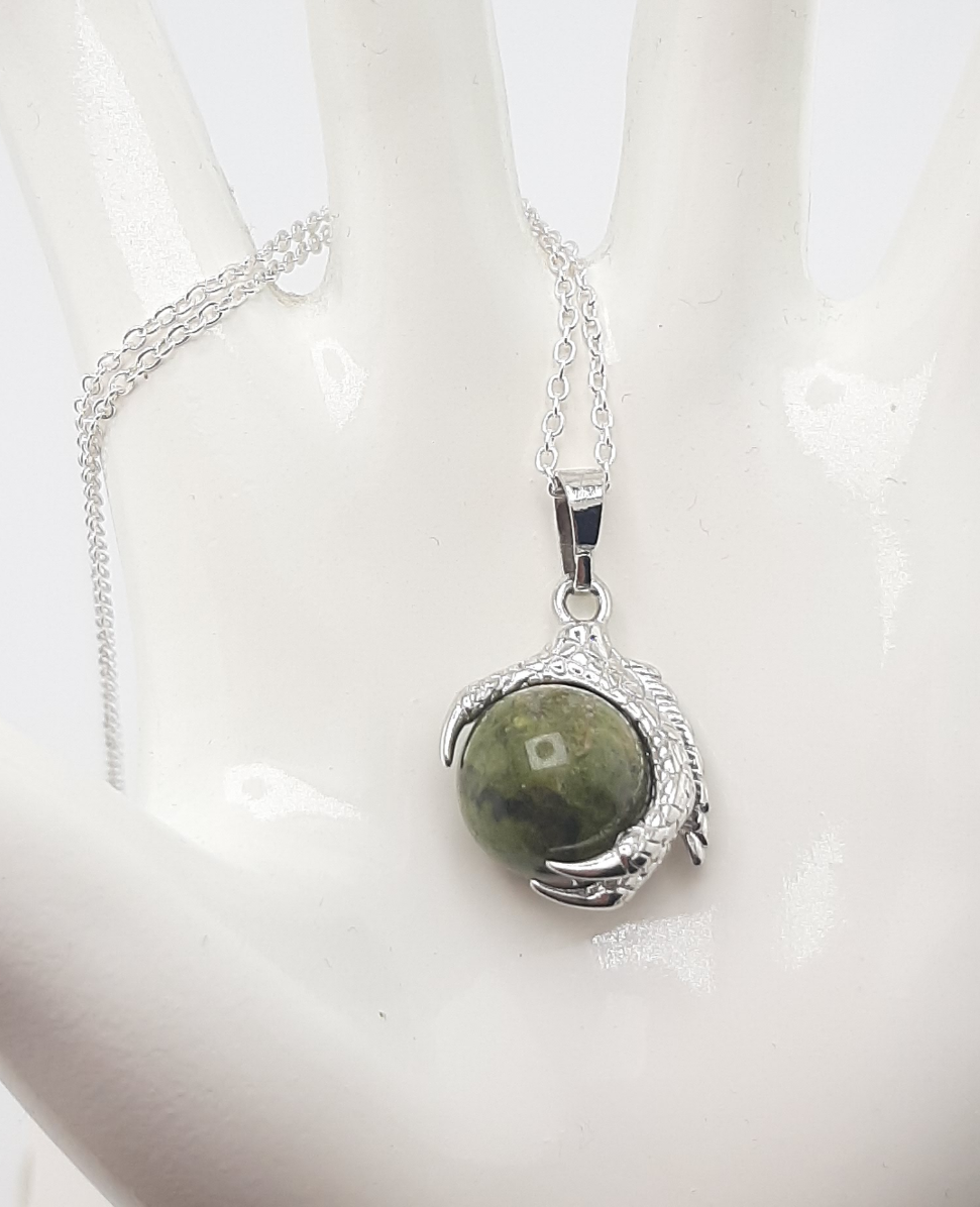 A men's necklace featuring an eagle claw pendant with sodalite stone set in silver, displayed against a black background with a leather-like choker.