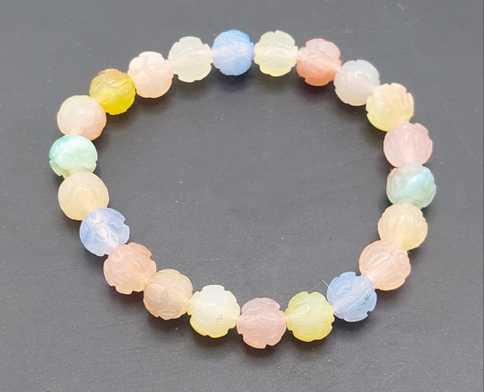 A multicolored beaded bracelet with a lotus flower design, likely made of stone or glass, displayed against a dark background.