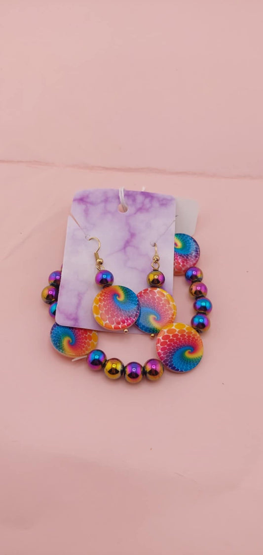 A set of multicolored beads and matching earrings presented on a pink surface.