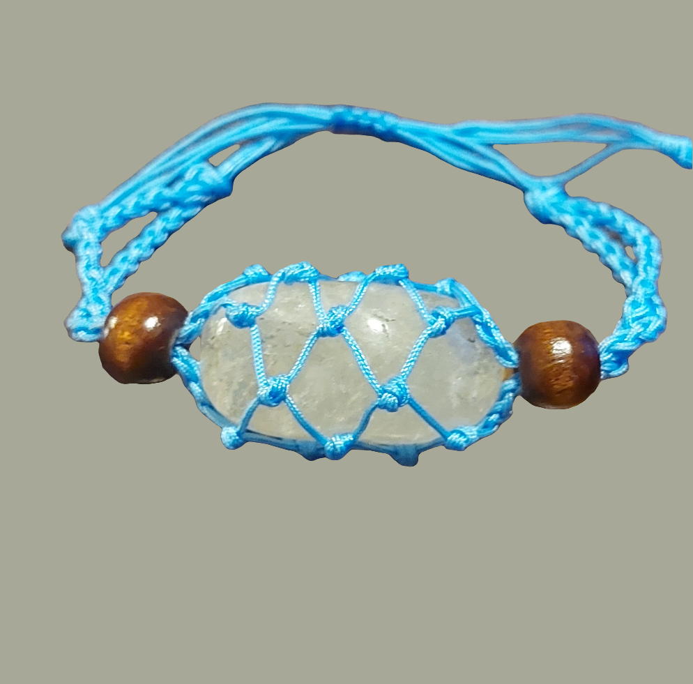 blue macrame clear quartz tumbled stone behind brown background