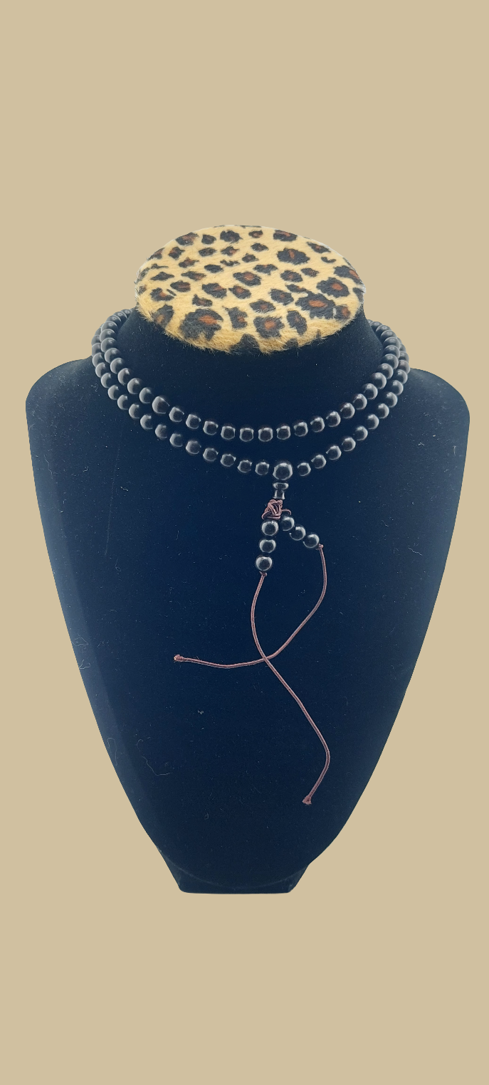 A bracelet and necklace set displayed on a mannequin with a leopard print shirt. The jewelry appears to be made of a scented wood material with a primarily silver color.