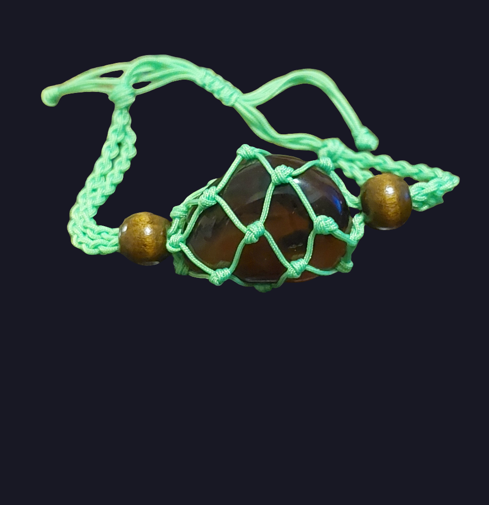 green macrame tumbled stone bracelet behind black background