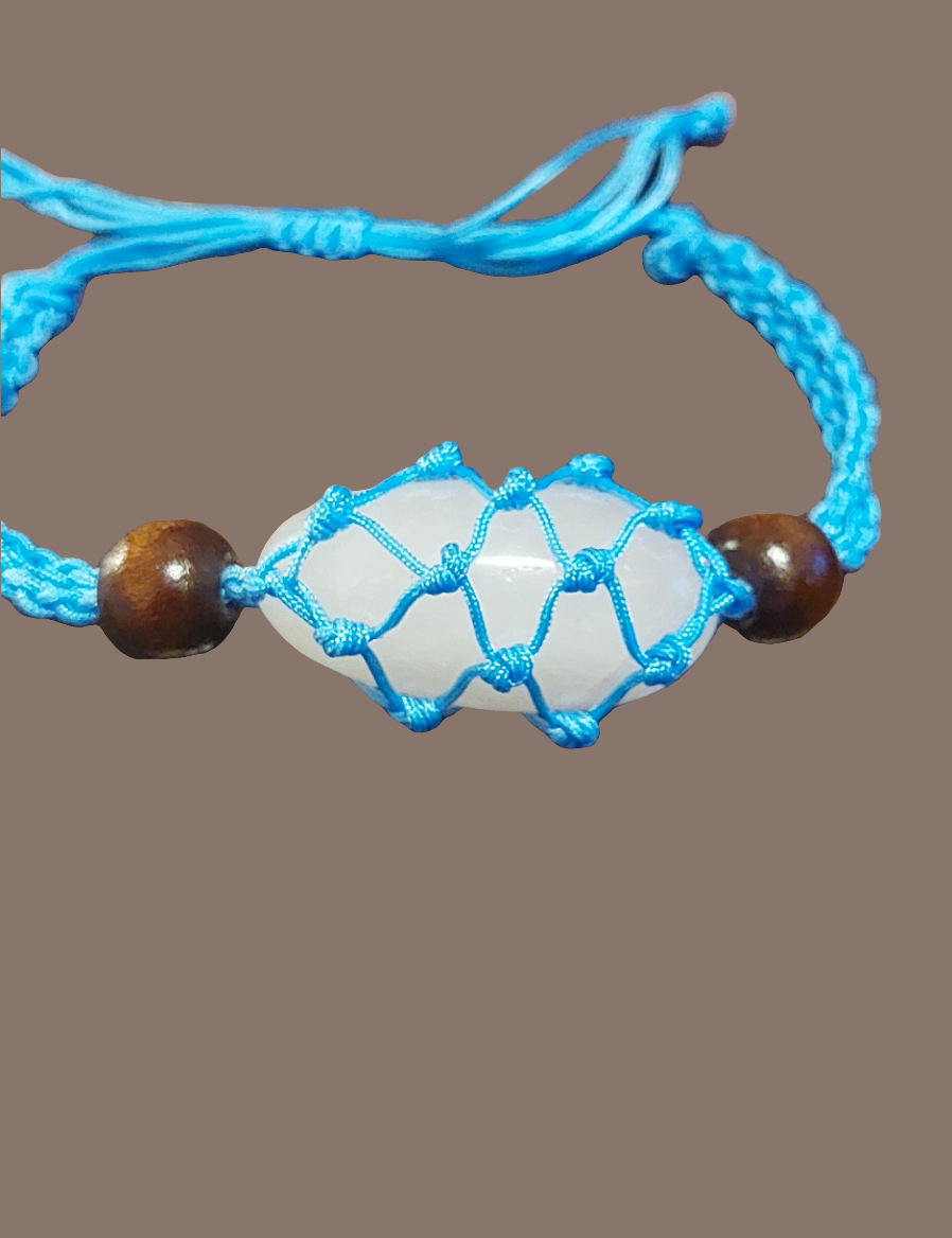 blue macrame clear quartz tumbled stone behind brown background