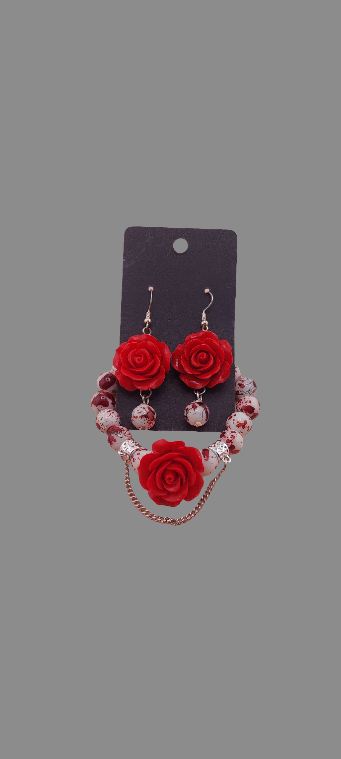 A set of accessories featuring a necklace and earrings with a floral design in red and black colors.