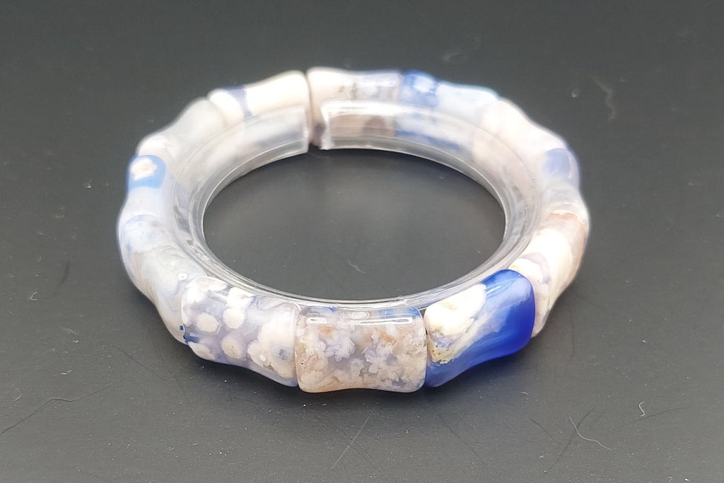 Decorative bracelet with blue and white pattern on a dark surface