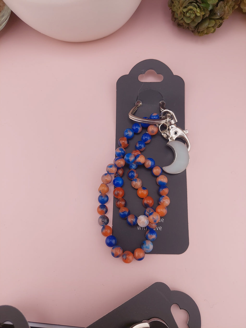 Beaded bracelet with hook on a pink surface
