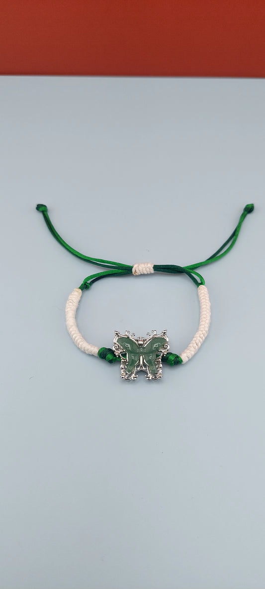 Adjustable bracelet with a satin cord and a butterfly-shaped charm, predominantly green and white in color.