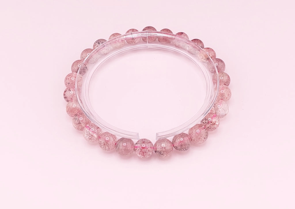 Pink beaded bracelet on a pink background