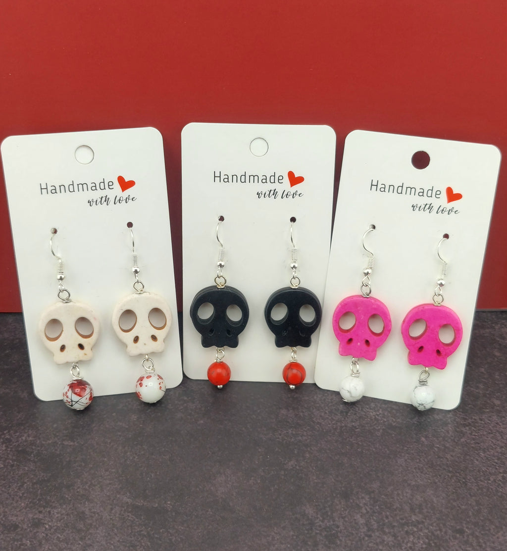 Set of skull-shaped earrings on cards with 'Handmade with Love' text against a red background.
