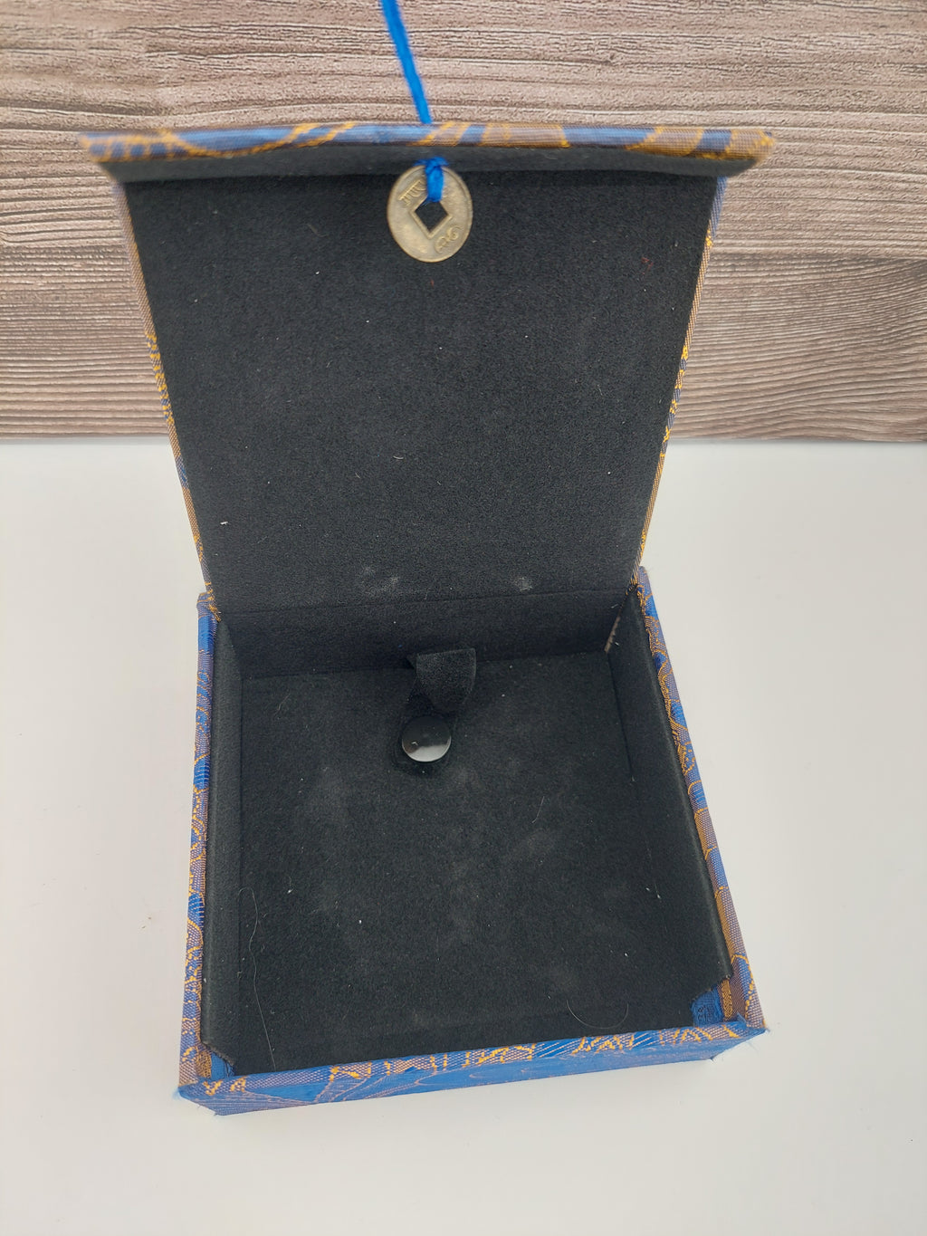 Open jewelry box with a ring inside on a wooden surface