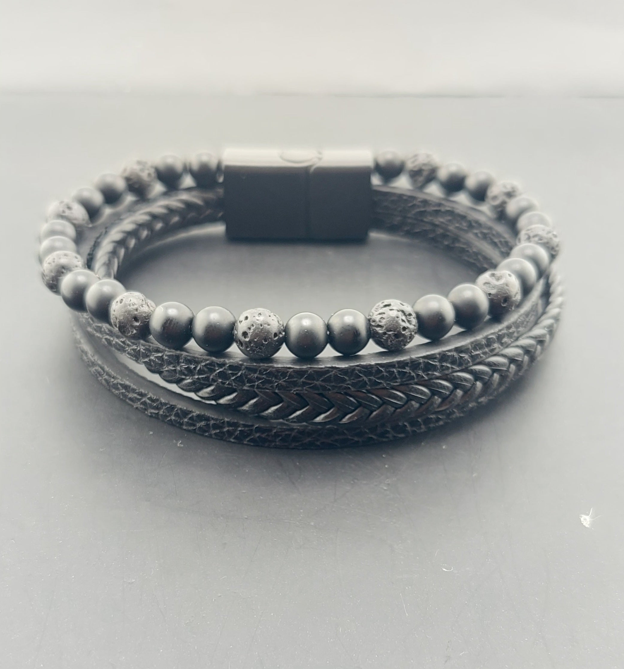 Bracelet with braided design and beaded section on a light gray background