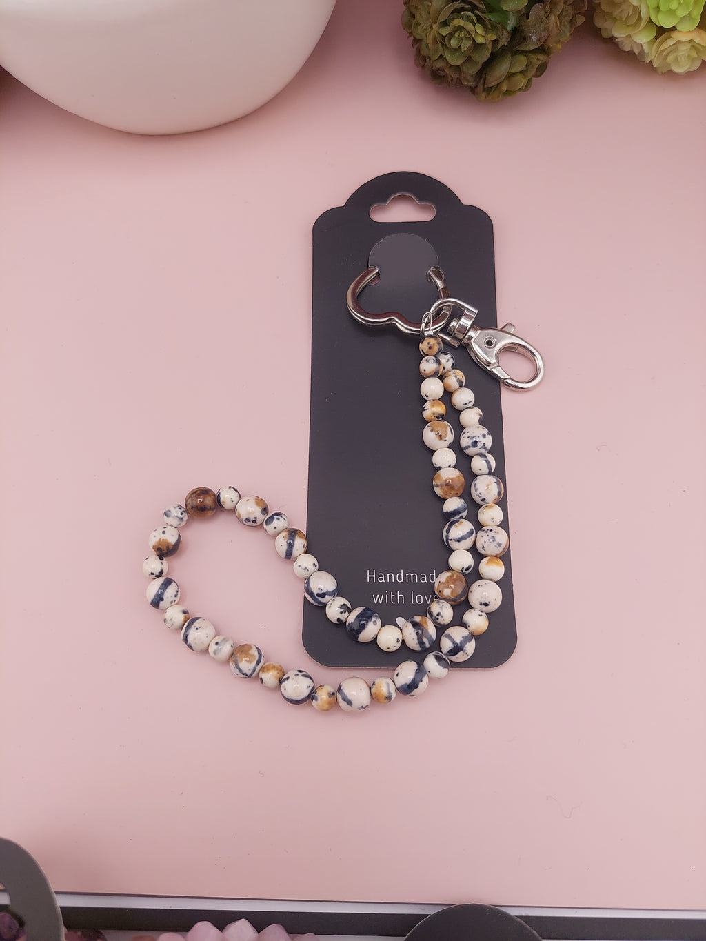Beaded lanyard with hook on a pink surface