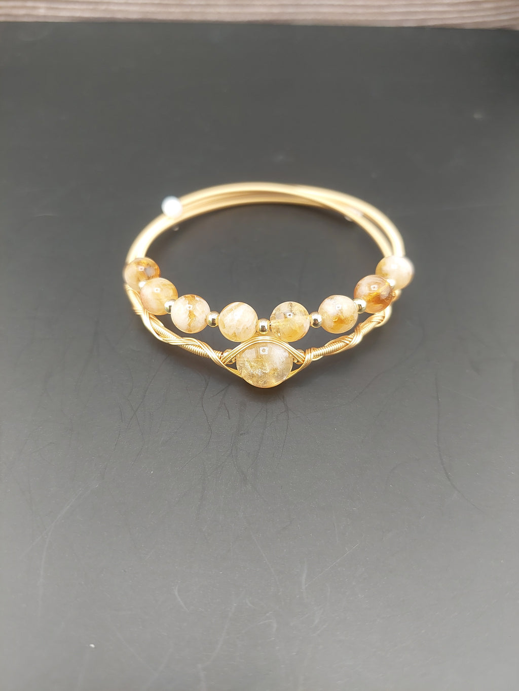 Gold hoop earring with embedded stones on a dark background