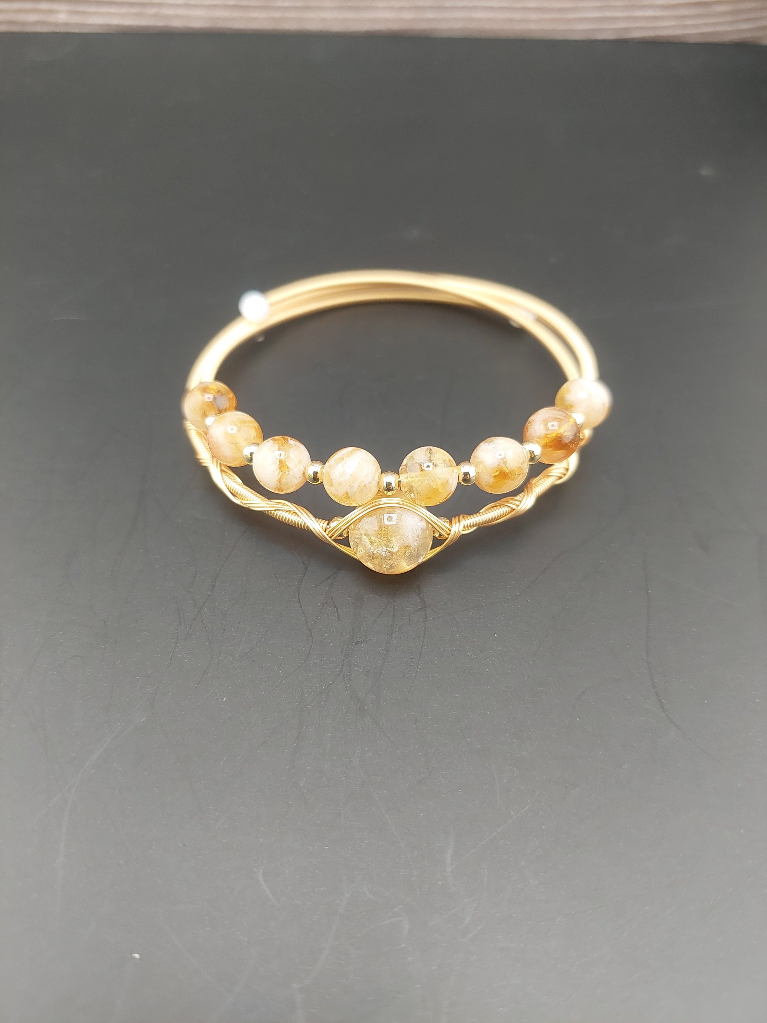 Gold hoop earring with embedded stones on a dark background