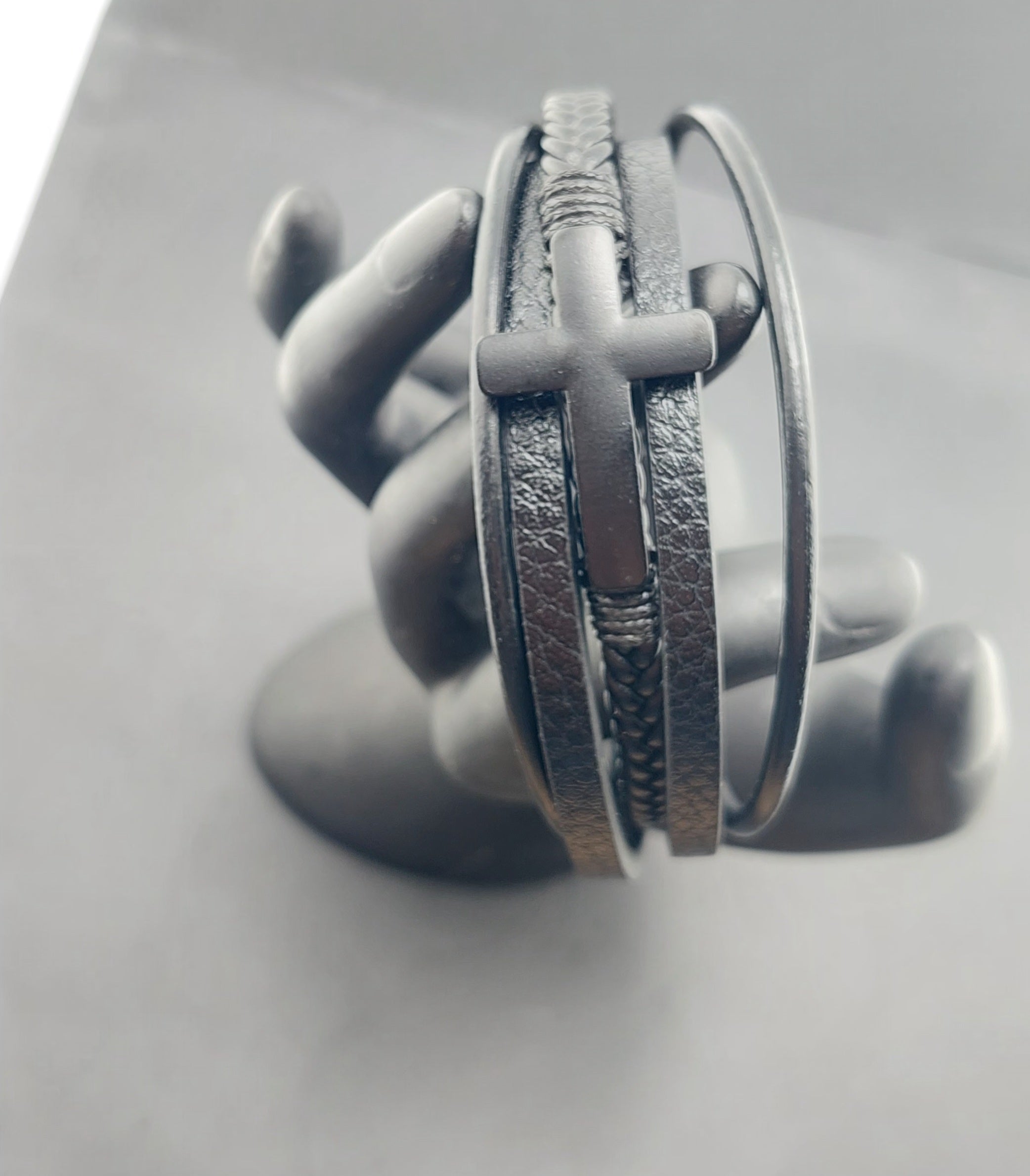 Silver bracelet on a gray mannequin hand with a plain background