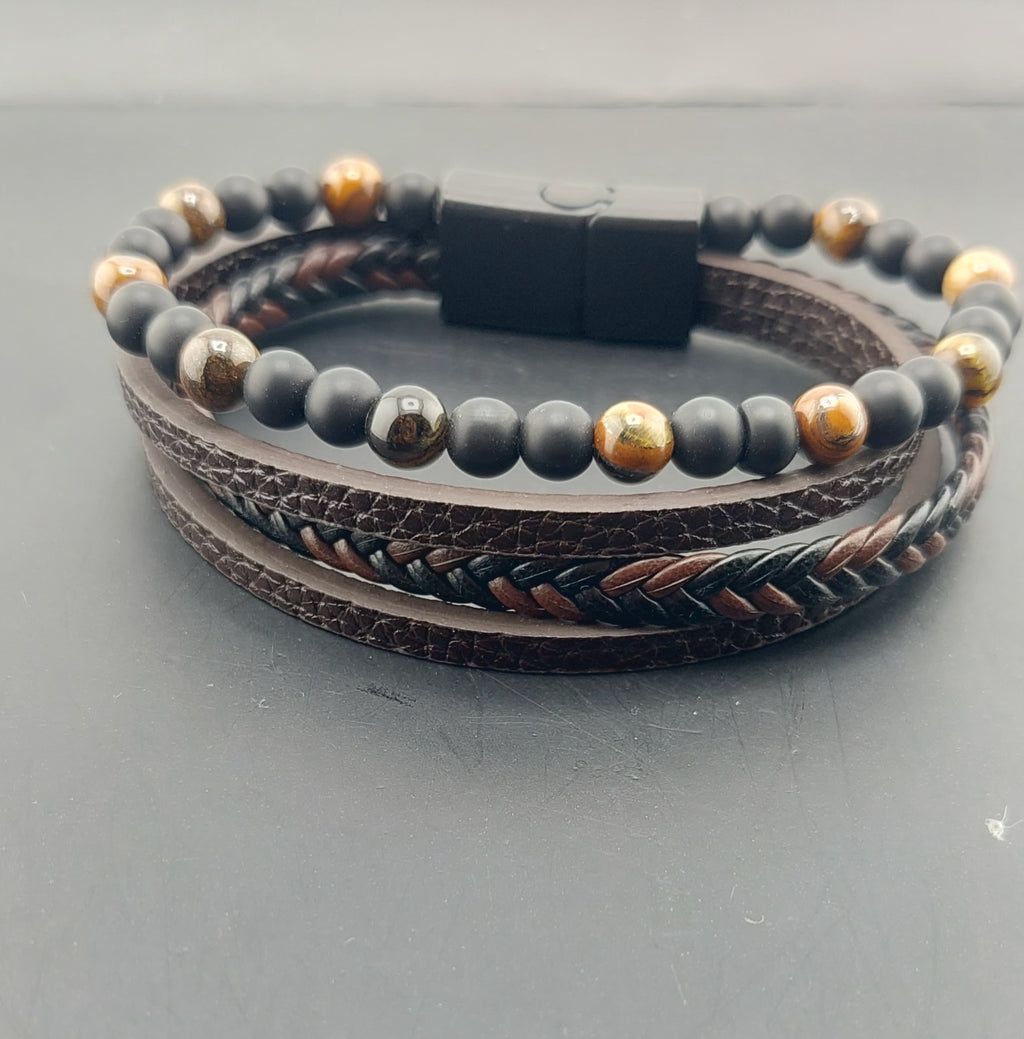 Multilayered bracelet with beads and leather strap on a gray background